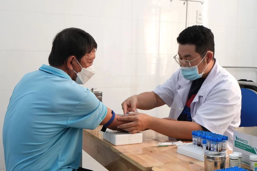 Thực hiện lấy máu xét nghiệm cho người dân tại chương trình.