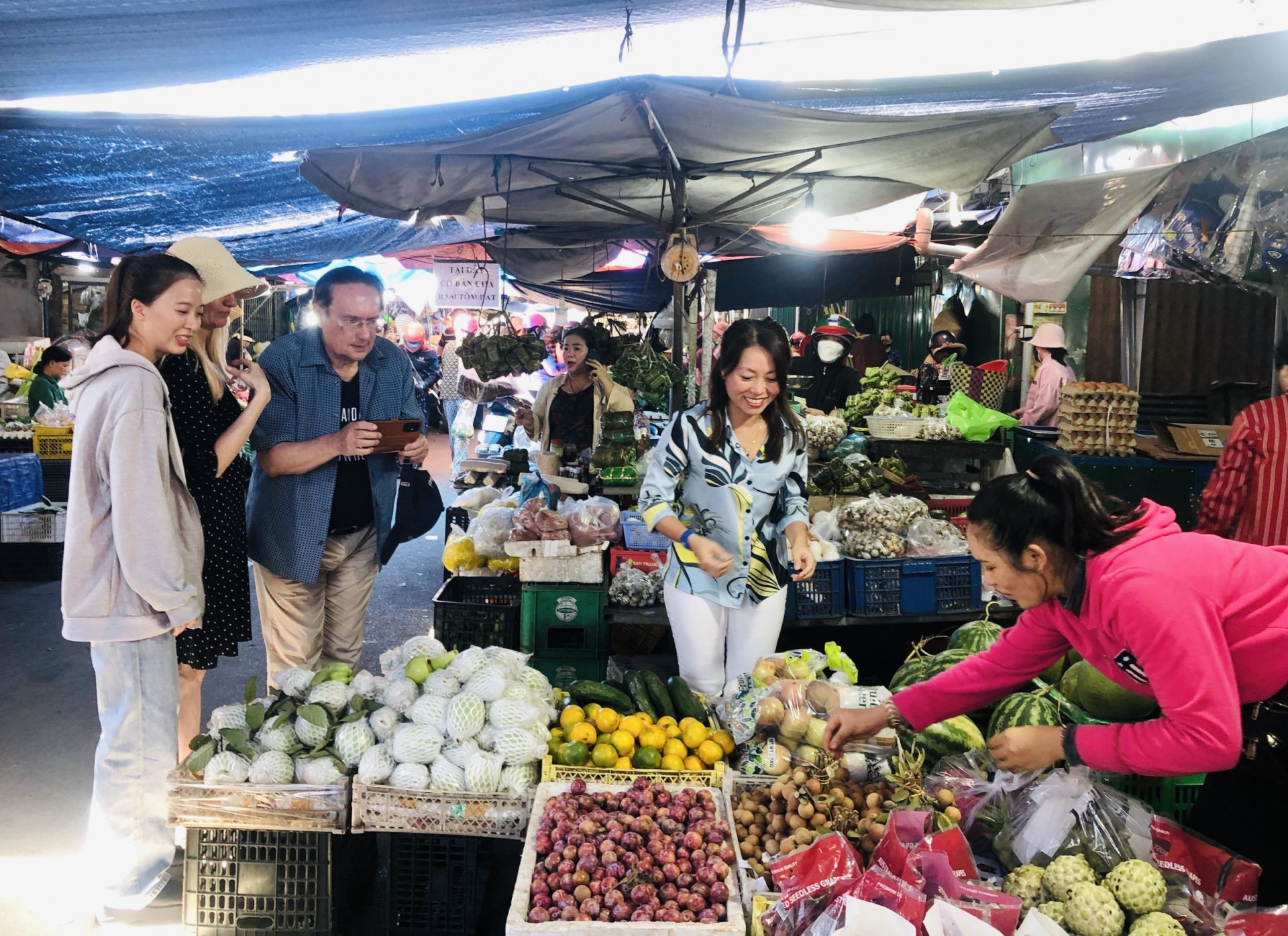 Chị Christina Nguyễn (thứ hai từ phải sang) dẫn khách đi chợ Cam Đức để tìm hiểu về đời sống người dân địa phương.