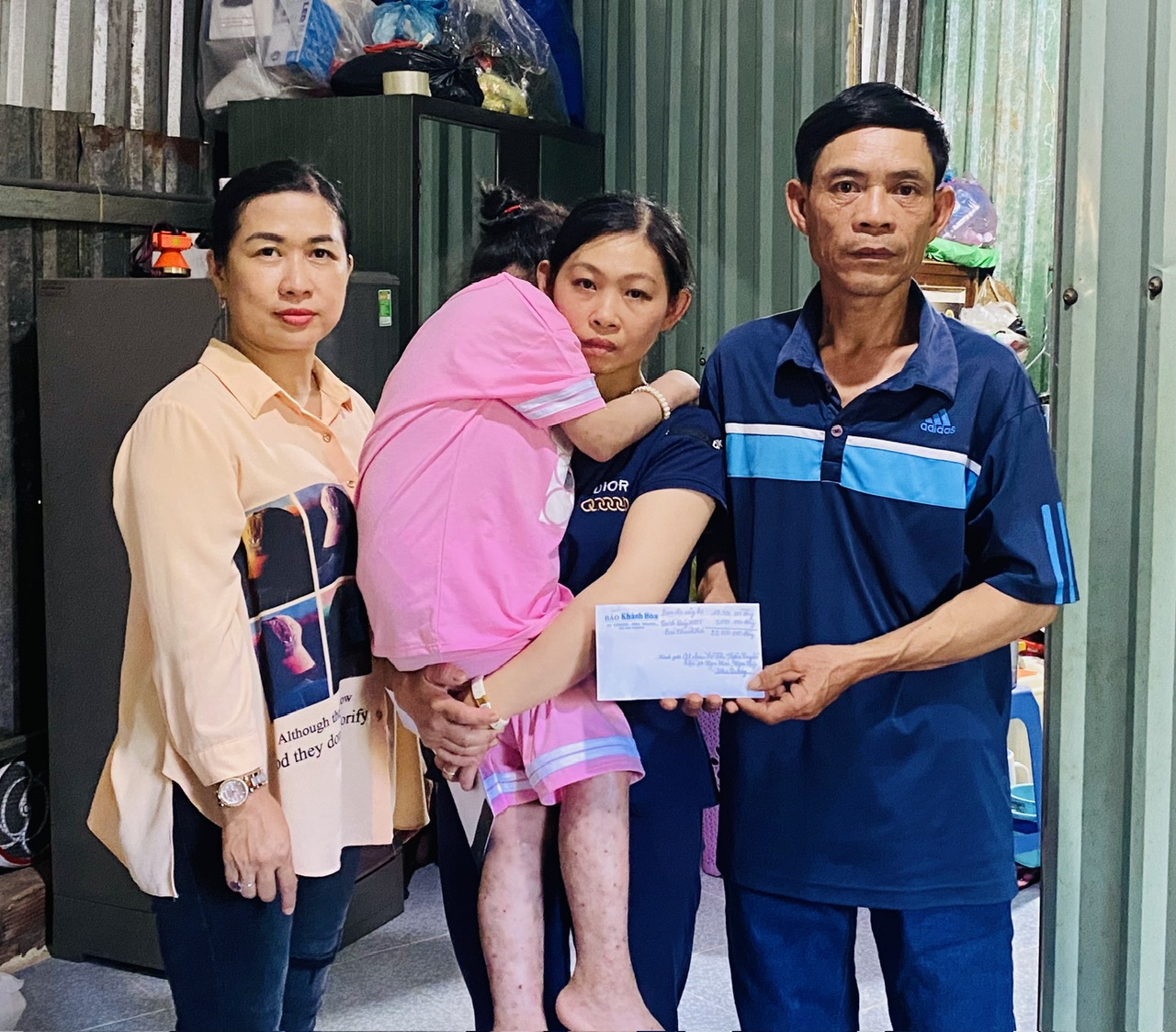 Đại diện Báo Khánh Hòa trao tiền ủng hộ của bạn đọc cho gia đình cháu Võ Thị Ngân Tuyền