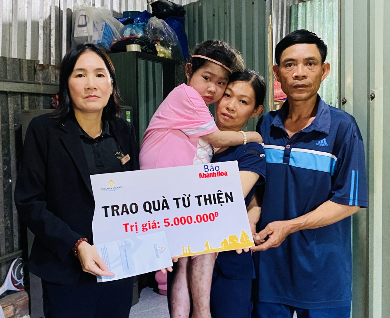 Đại diện Công ty Cổ phần Đầu tư Champagroup - Khu du lịch Champa Island Nha Trang trao tiền ủng hộ cho gia đình cháu Võ Thị Ngân Tuyền