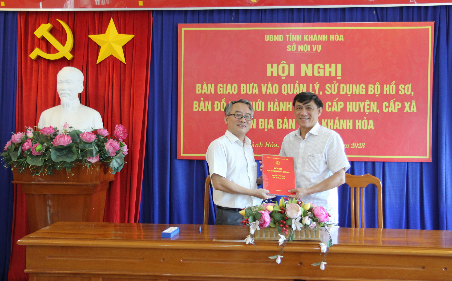 Ông Võ Chí Vương bàn giao hồ sơ, bản đồ địa giới hành chính huyện Vạn Ninh cho lãnh đạo UBND huyện.