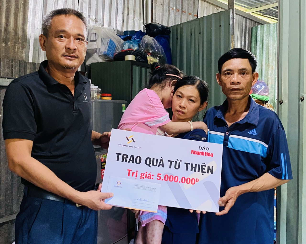 Ông Trần Khánh Định - Phó Giám đốc Công ty TNHH Tư vấn và Đầu tư Trung Tín trao tiền ủng hộ cho gia đình cháu Võ Thị Ngân Tuyền