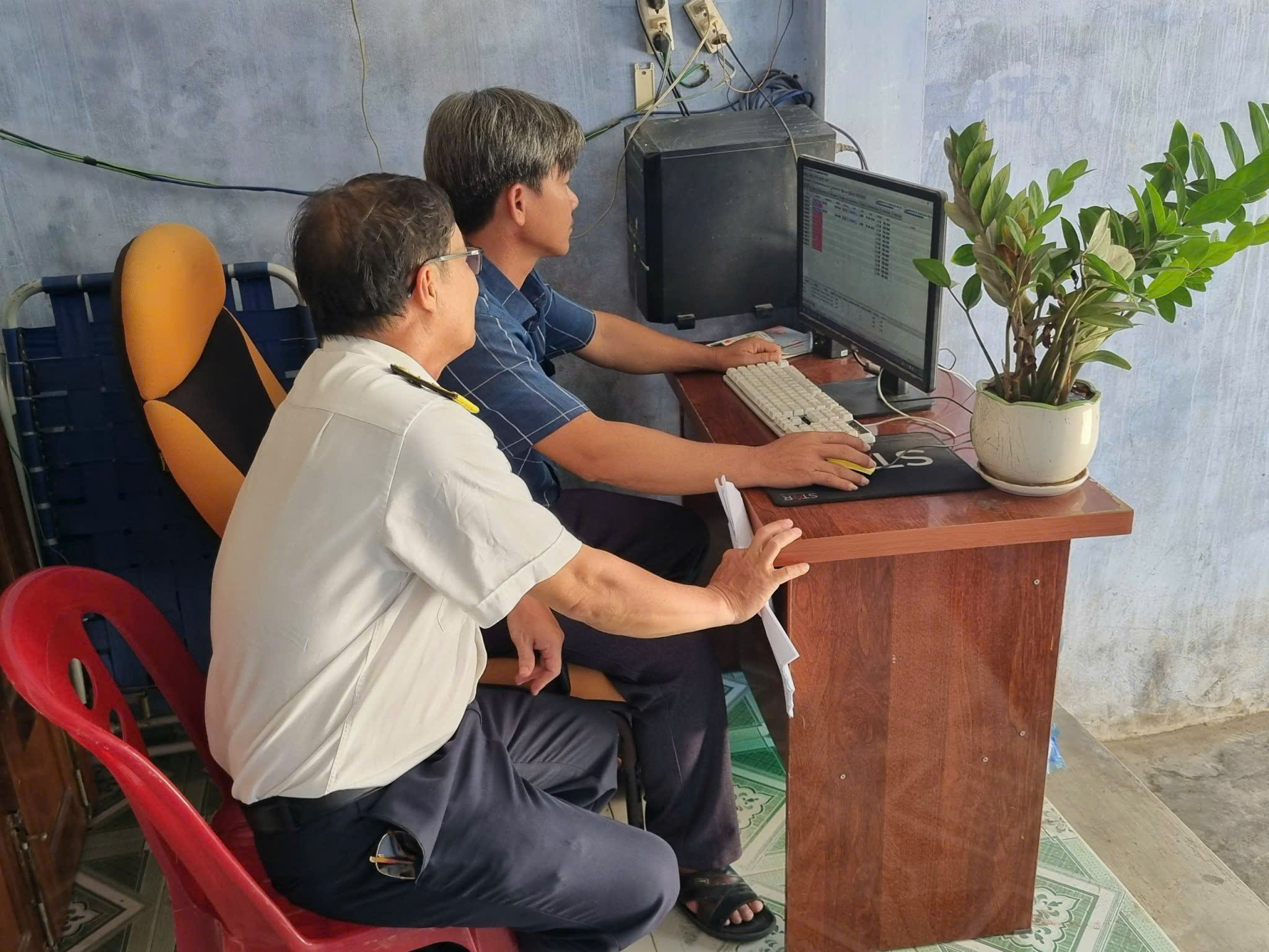 Cán bộ Chi cục Thuế khu vực Bắc Khánh Hòa hỗ trợ hộ kinh doanh tra cứu thông tin 