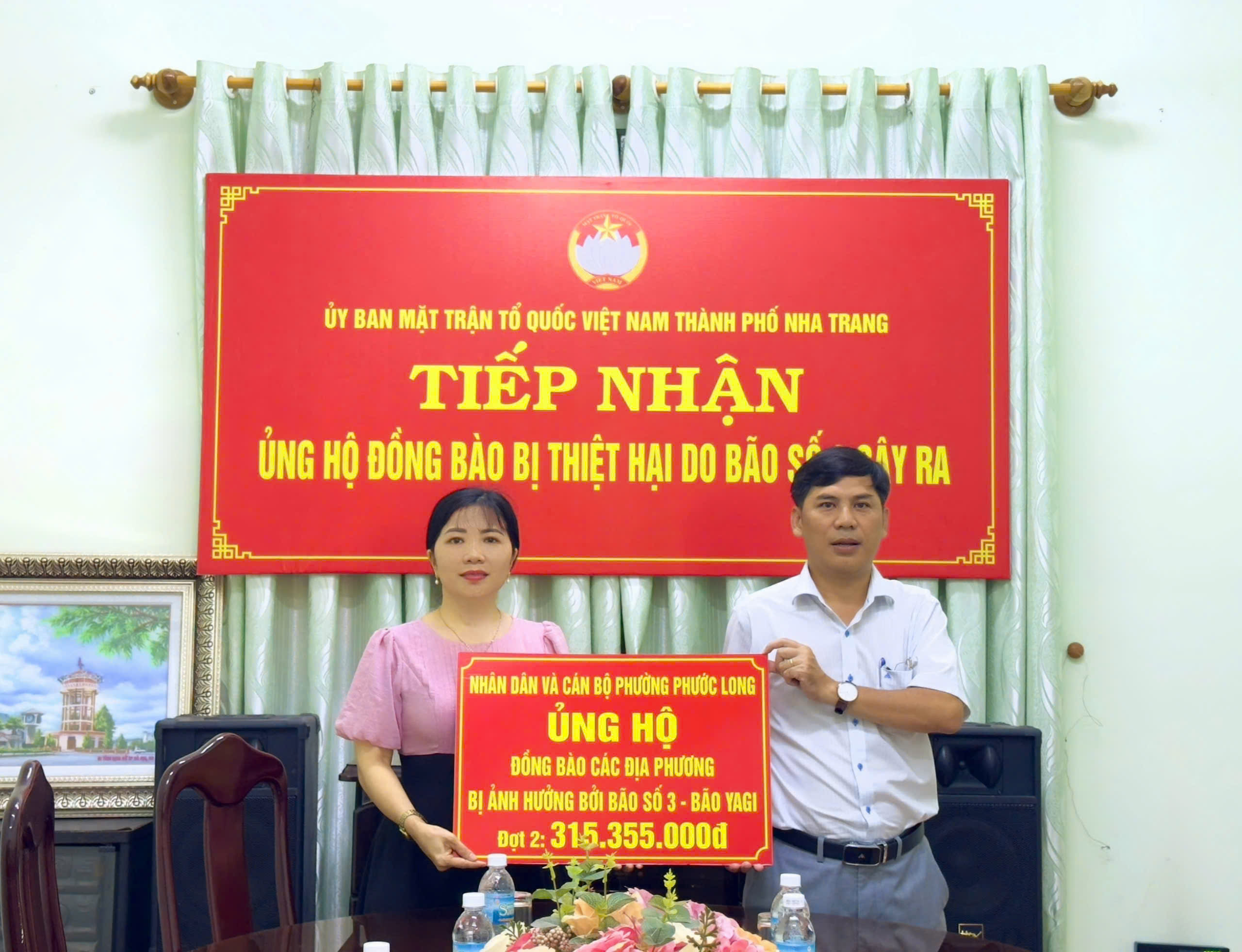 Lãnh đạo UBMTTQ Việt Nam TP. Nha Trang (bìa phải) tiếp nhận ủng hộ đợt 2 từ phường Phước Long