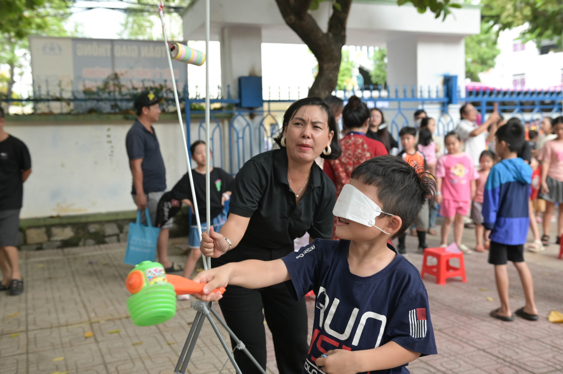 Các em thiếu nhi chơi bịt mắt đập vỏ lon để nhận được phiếu đổi quà.