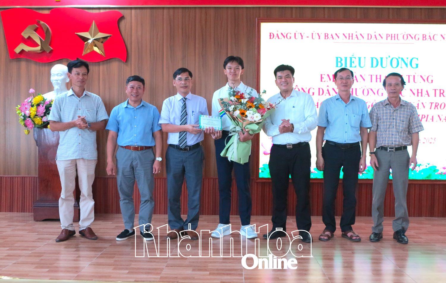 Lãnh đạo phường tặng hoa chúc mừng và tiền thưởng 2 triệu đồng cho em Tùng. 