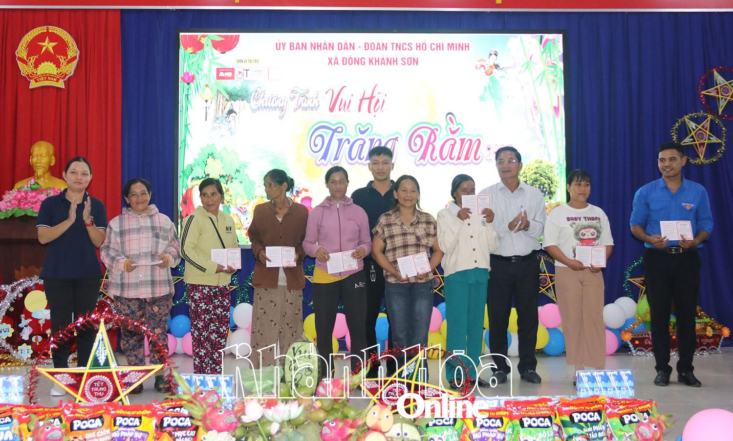 Lãnh đạo xã Đông Khánh Sơn và Quỹ Phát triển cộng đồng tỉnh trao sổ tiết kiệm cho gia đình các tân sinh viên có hoàn cảnh khó khăn.