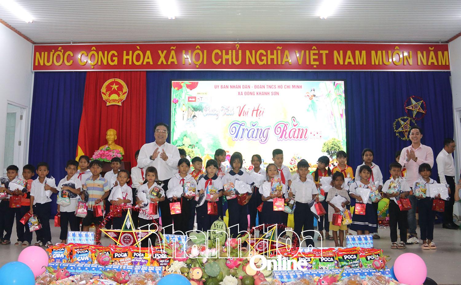 Lãnh đạo xã và đại diện Nhóm thiện nguyện Áo Trắng tặng quà cho các em học sinh.