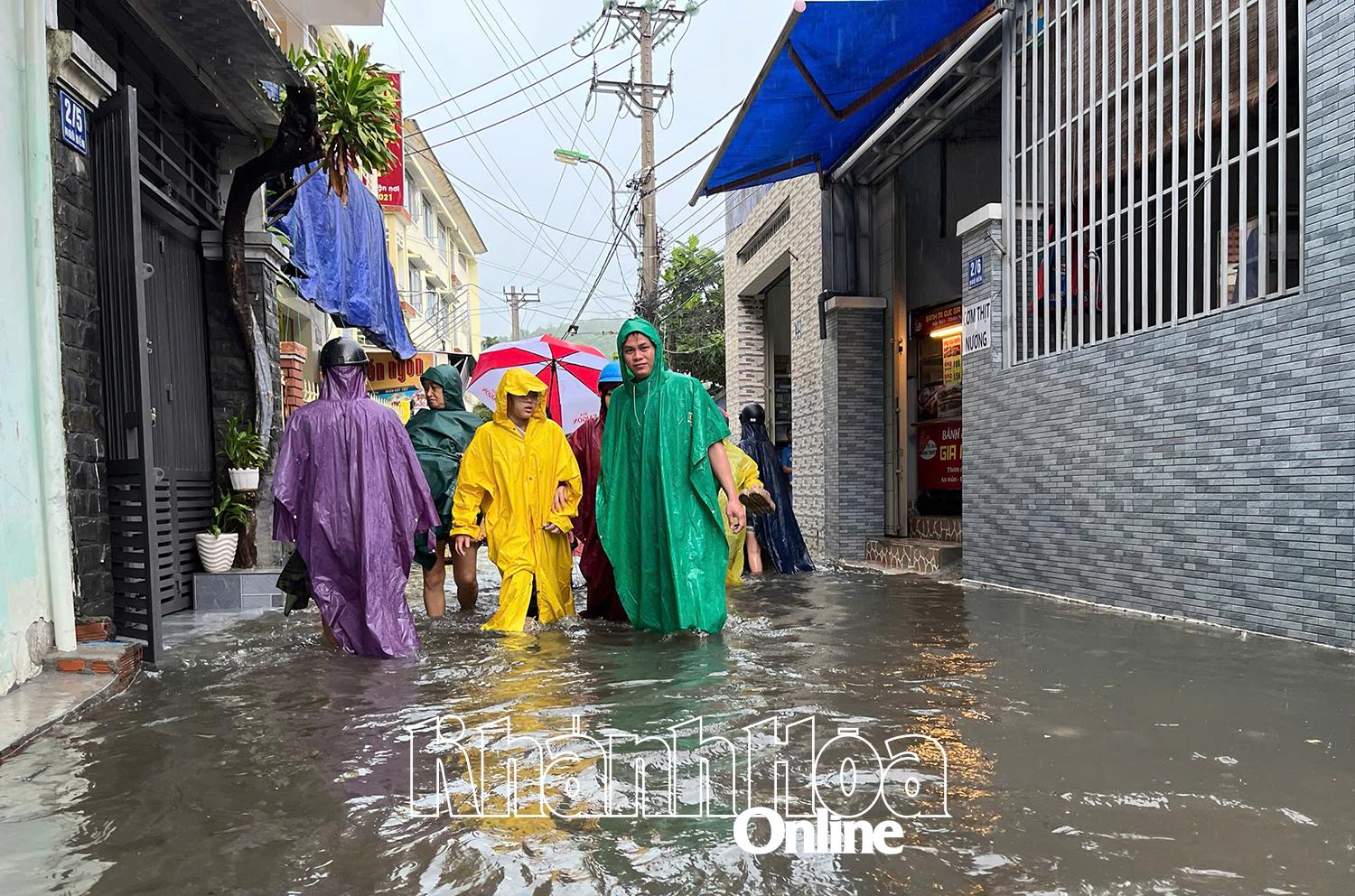 Đường Ngô Đến (phường Bắc Nha Trang) bị ngập nặng. Nhiều phụ huynh lội nước đưa con đến trường học.
