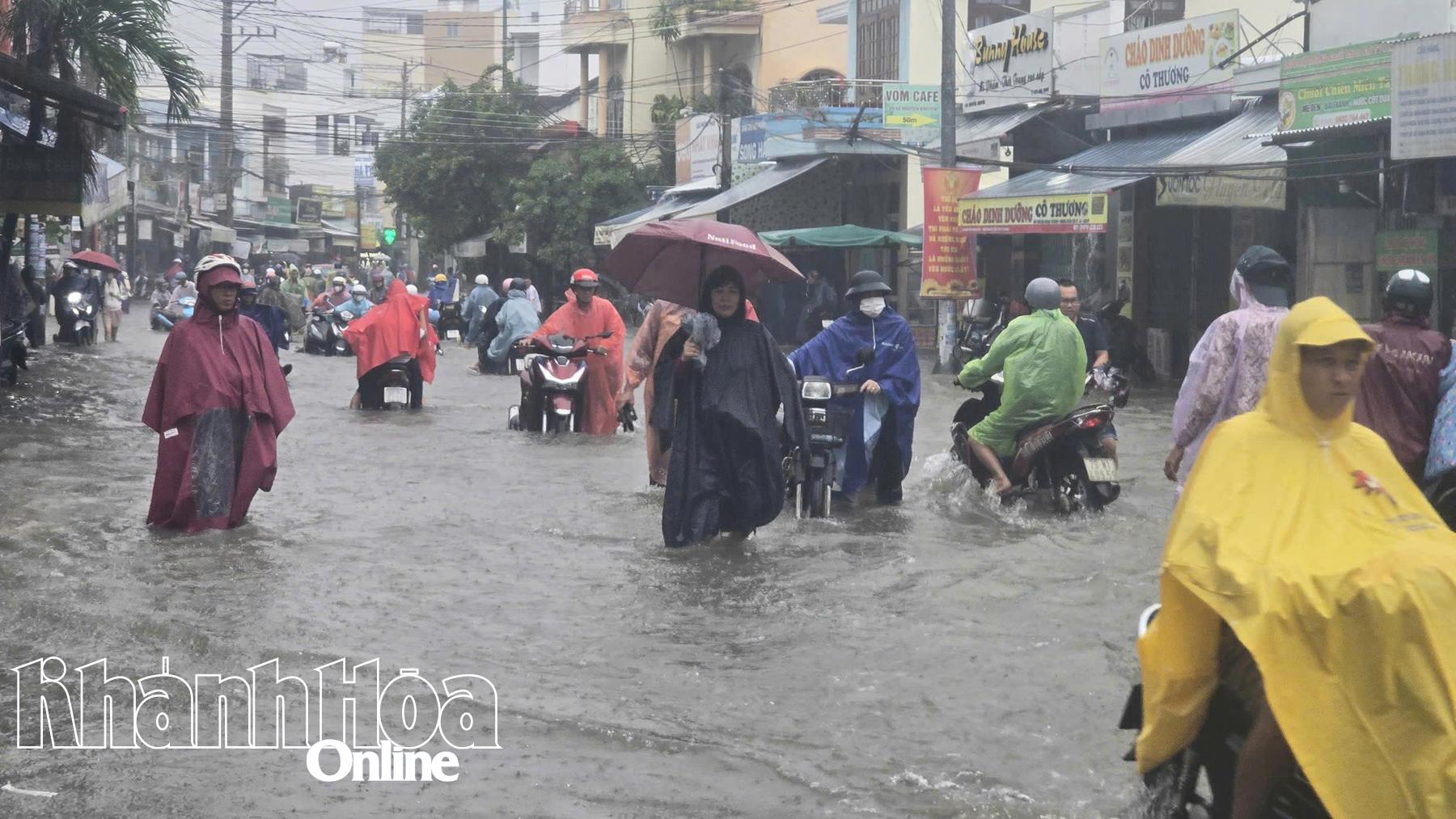 Đường Nguyễn Khuyến (phường Bắc Nha Trang) bị ngập sâu. Người đi đường phải dắt bộ xe máy

