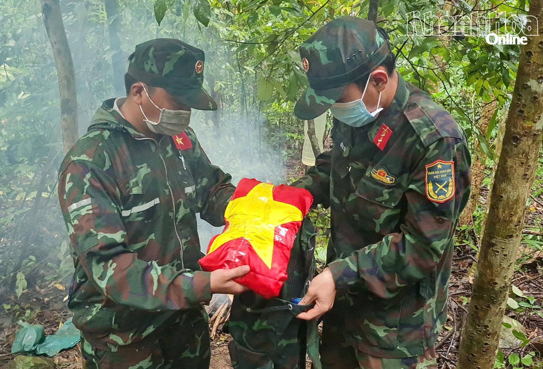 Cán bộ, chiến sĩ cẩn thận đặt hài cốt liệt sĩ vào ba lô để đưa xuống núi.