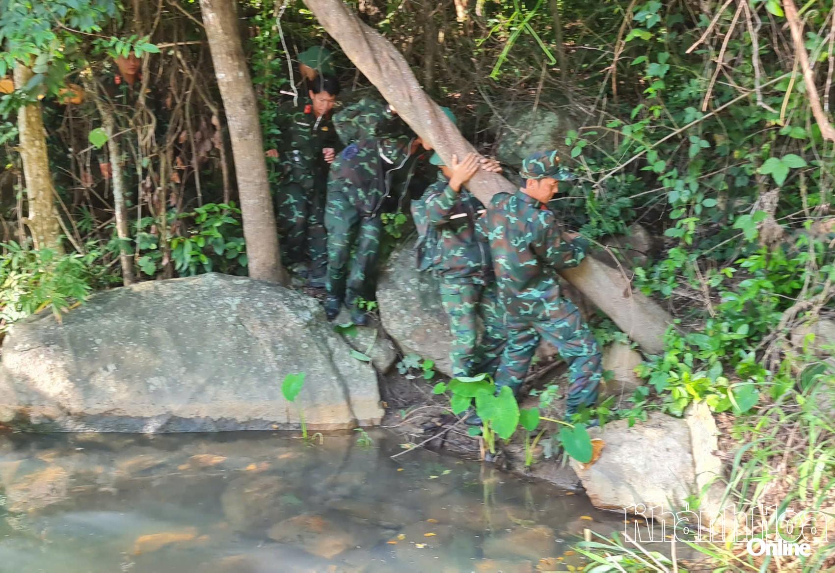 Các thành viên thận trọng vượt qua một con suối trên đường lên núi.