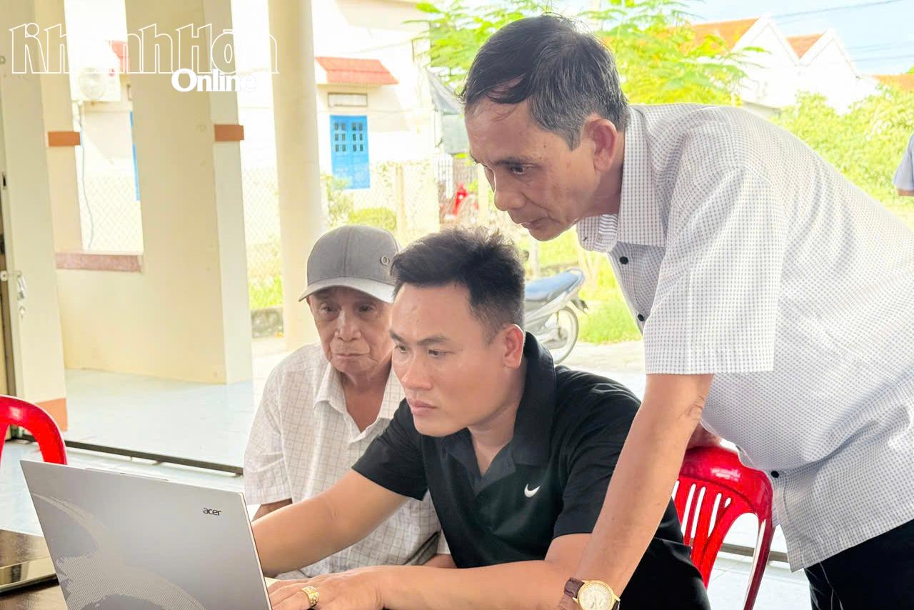 Anh Lê Hữu Tâm (ngồi giữa) thành viên Tổ công nghệ số cộng đồng Tổ dân phố Ninh Thủy 1, phường Đông Ninh Hòa hướng dẫn người dân tiếp cận công nghệ số. 