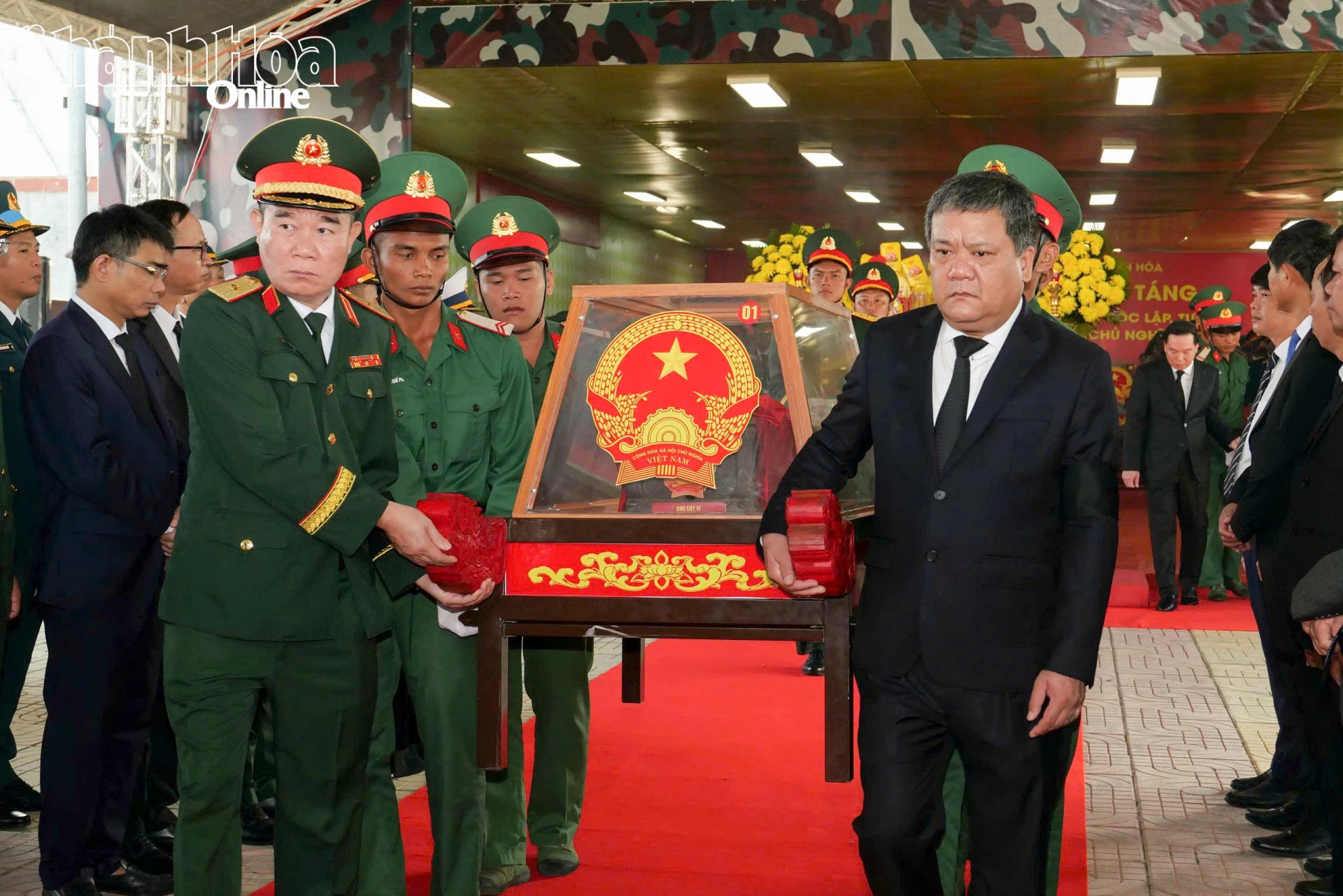 Đồng chí Trần Phong, các đại biểu cùng lực lượng tiêu binhdi chuyển các hài cốt liệt sĩ đến ô mộ để an táng.