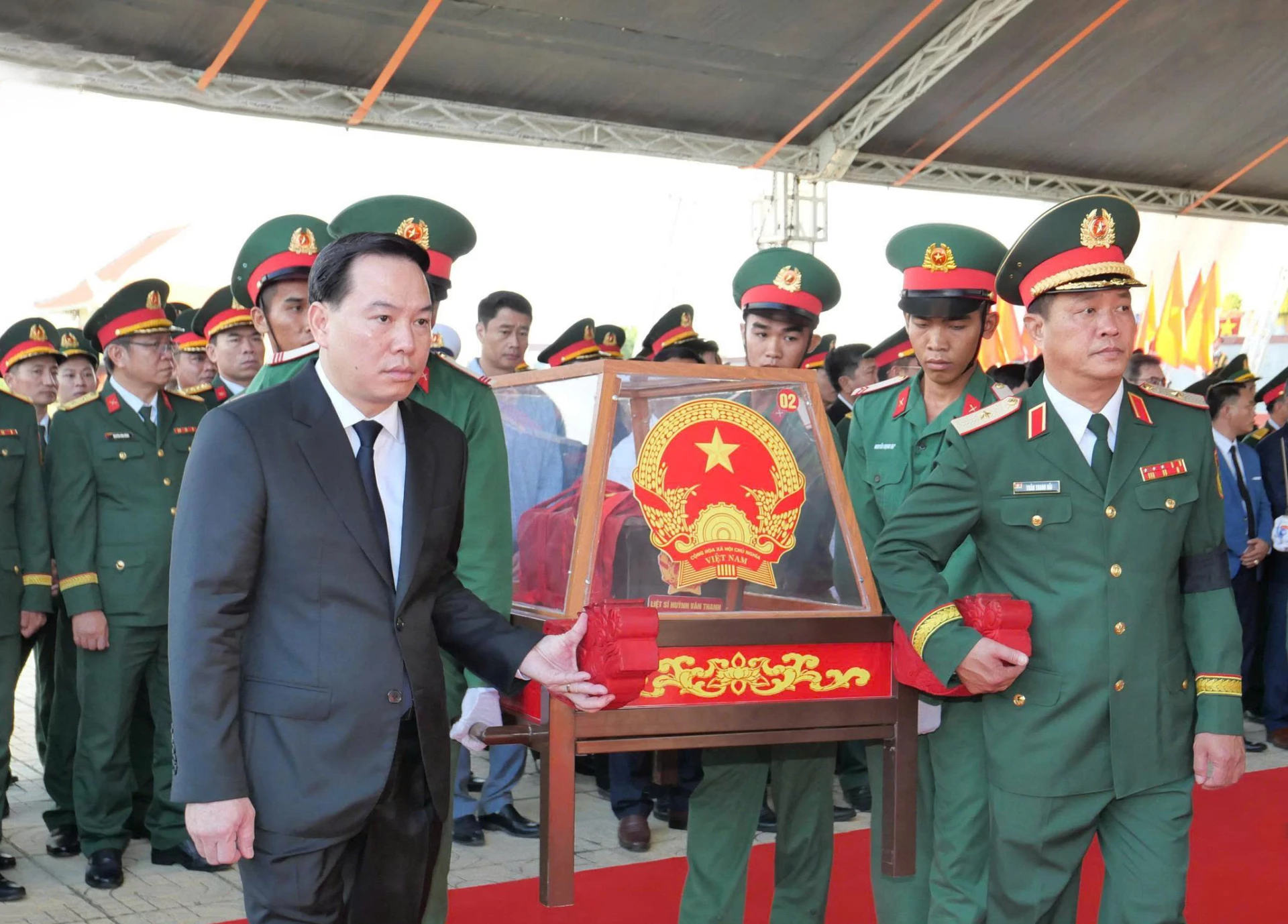 Đồng chí Hồ Xuân Trường, các đại biểu cùng lực lượng tiêu binh di chuyển các hài cốt liệt sĩ đến ô mộ để an táng.