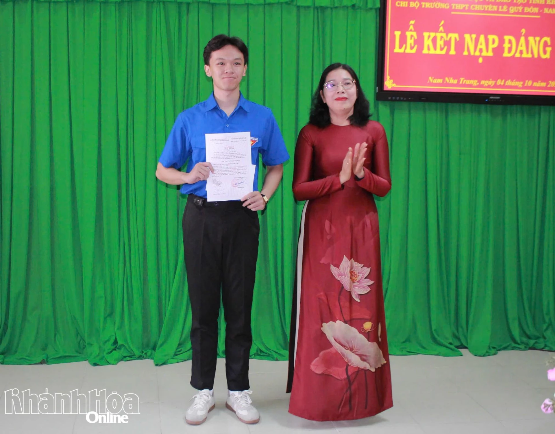 Cô Đặng Ngọc Lệ Thy trao quyết định kết nạp đảng viên mới cho em Đoàn Thanh Tùng.