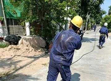 Lưng áo ướt đẫm mồ hôi của người thợ điện khi kéo từng mét cáp điện dưới nắng hè gay gắt tại khu vực Tây Nha Trang.