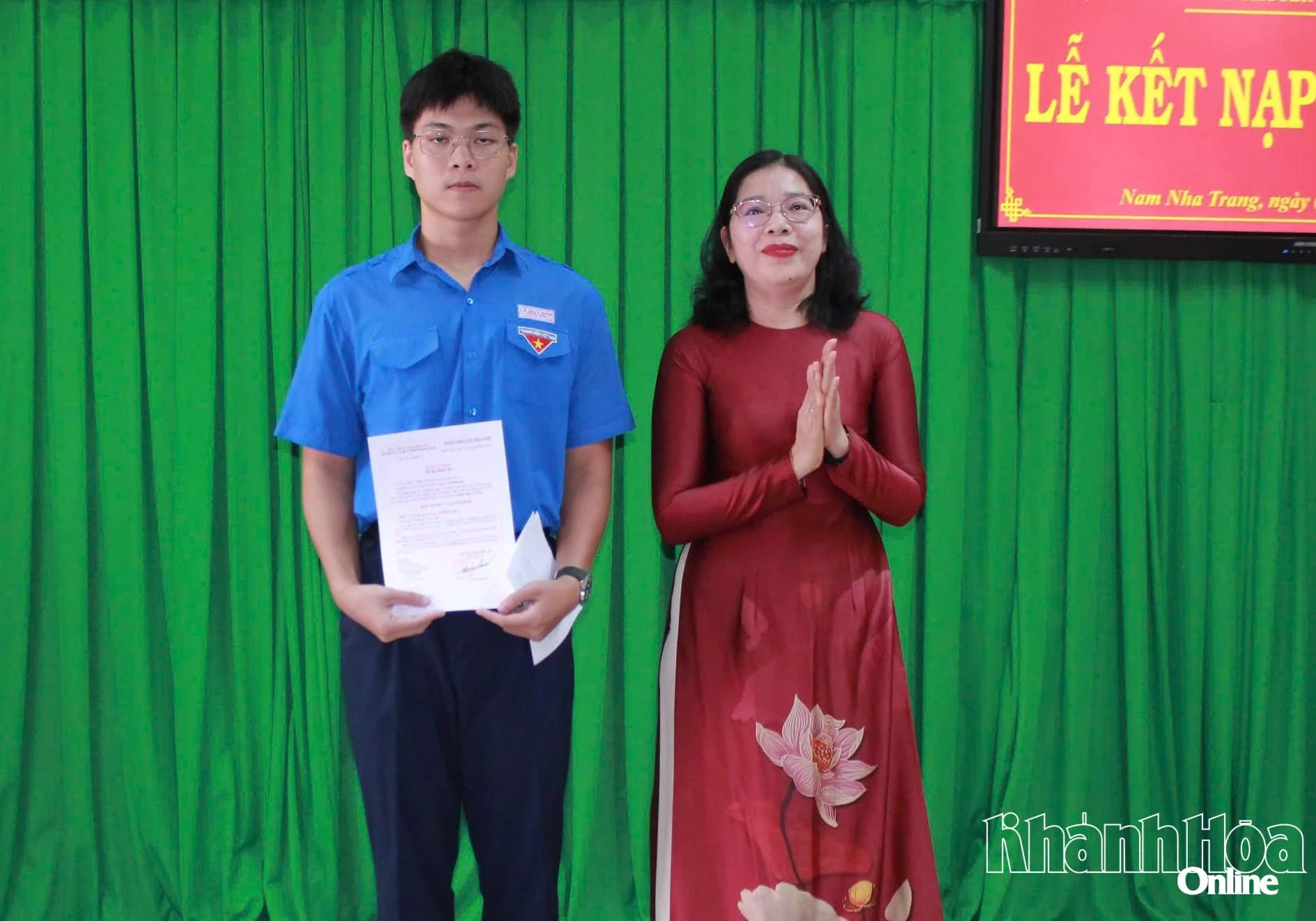 Cô Đặng Ngọc Lệ Thy trao quyết định kết nạp đảng viên mới cho em Vũ Minh Huy.