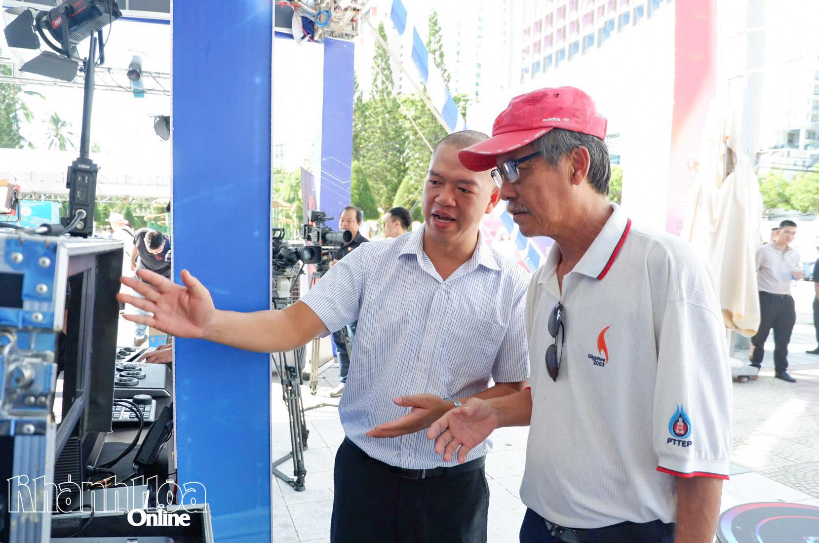 Đại diện Công ty TNHH Nghe nhìn Nam Long - Chi nhánh TP. Hồ Chí Minh giới thiệu khách tham quan gian hàng về thiết bị cân chỉnh màu sắc.