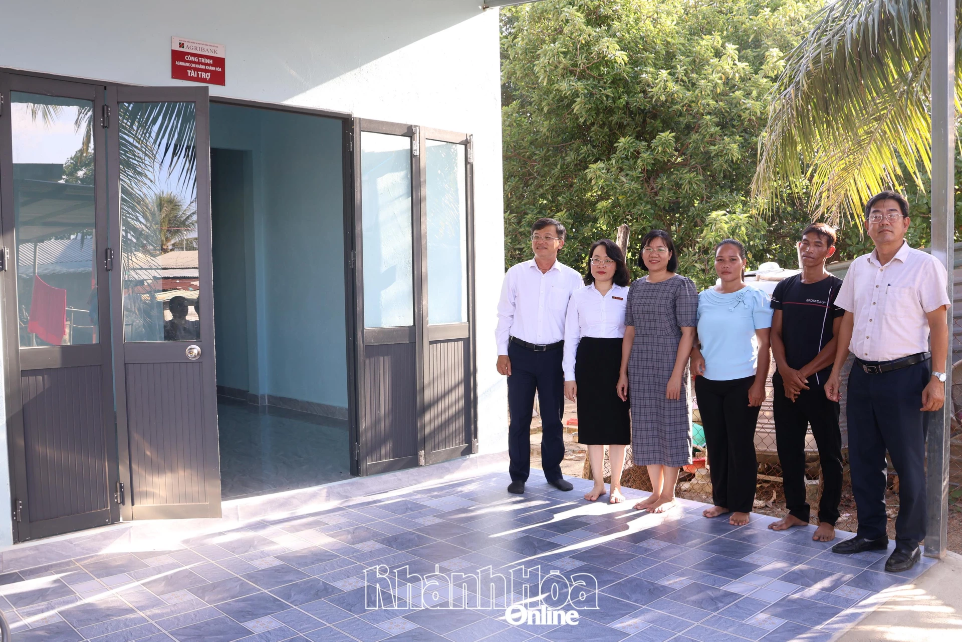 Lãnh đạo xã Suối Dầu, đại diện Ngân hàng Agribank chụp hình cùng ngôi nhà mới