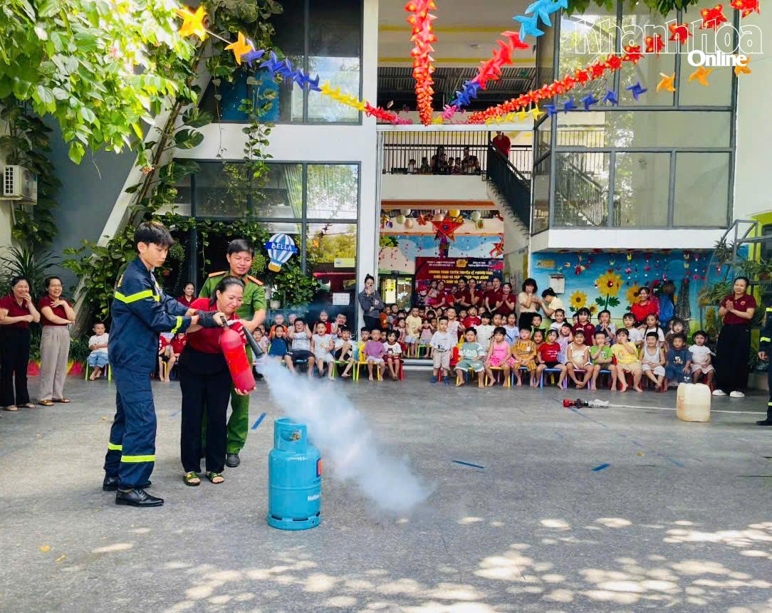 Dưới sự hướng dẫn của chiến sĩ chữa cháy, các giáo viên được thực hành dập lửa bằng bình chữa cháy xách tay.