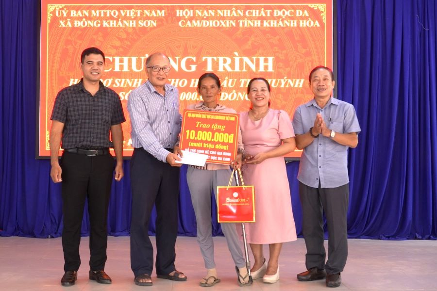 Lãnh đạo Hội Nạn nhân chất độc da cam/dioxin tỉnh và xã Đông Khánh Sơn trao bảng tượng trưng hỗ trợ sinh kế 10 triệu đồng cho bà Mấu Thị Huýnh.