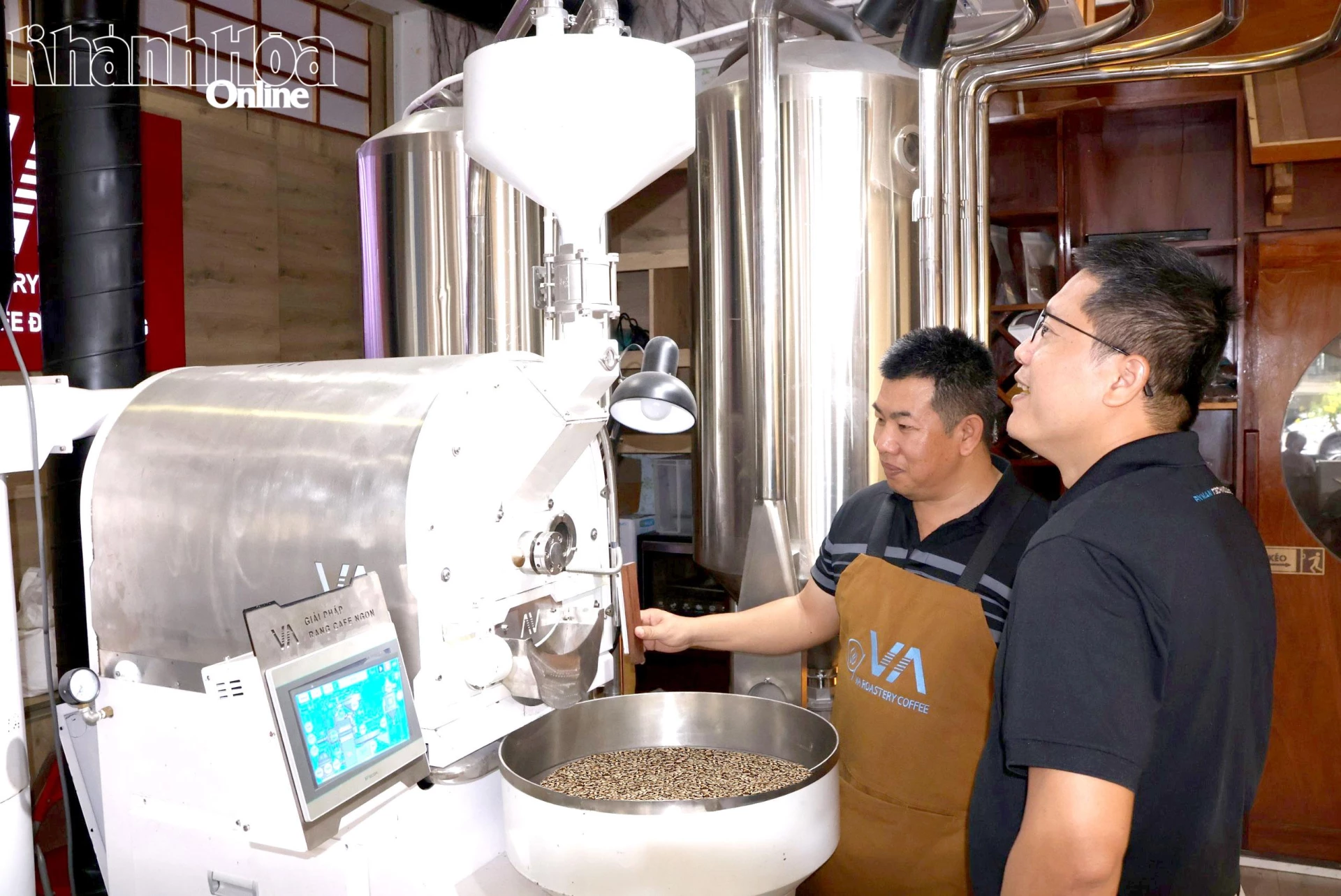 Ông Phan Thạch Vũ (bên trái) giới thiệu máy rang cà phê thông minh với khách hàng.