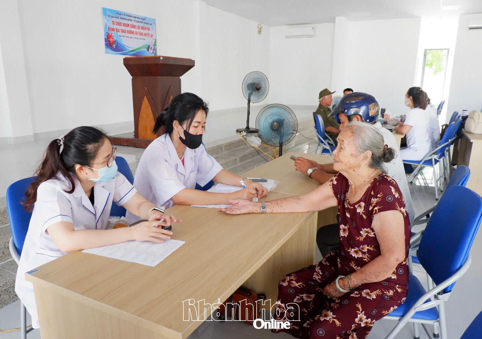 Cán bộ y tế phường thu thập thông tin triệu chứng bệnh của người dân.