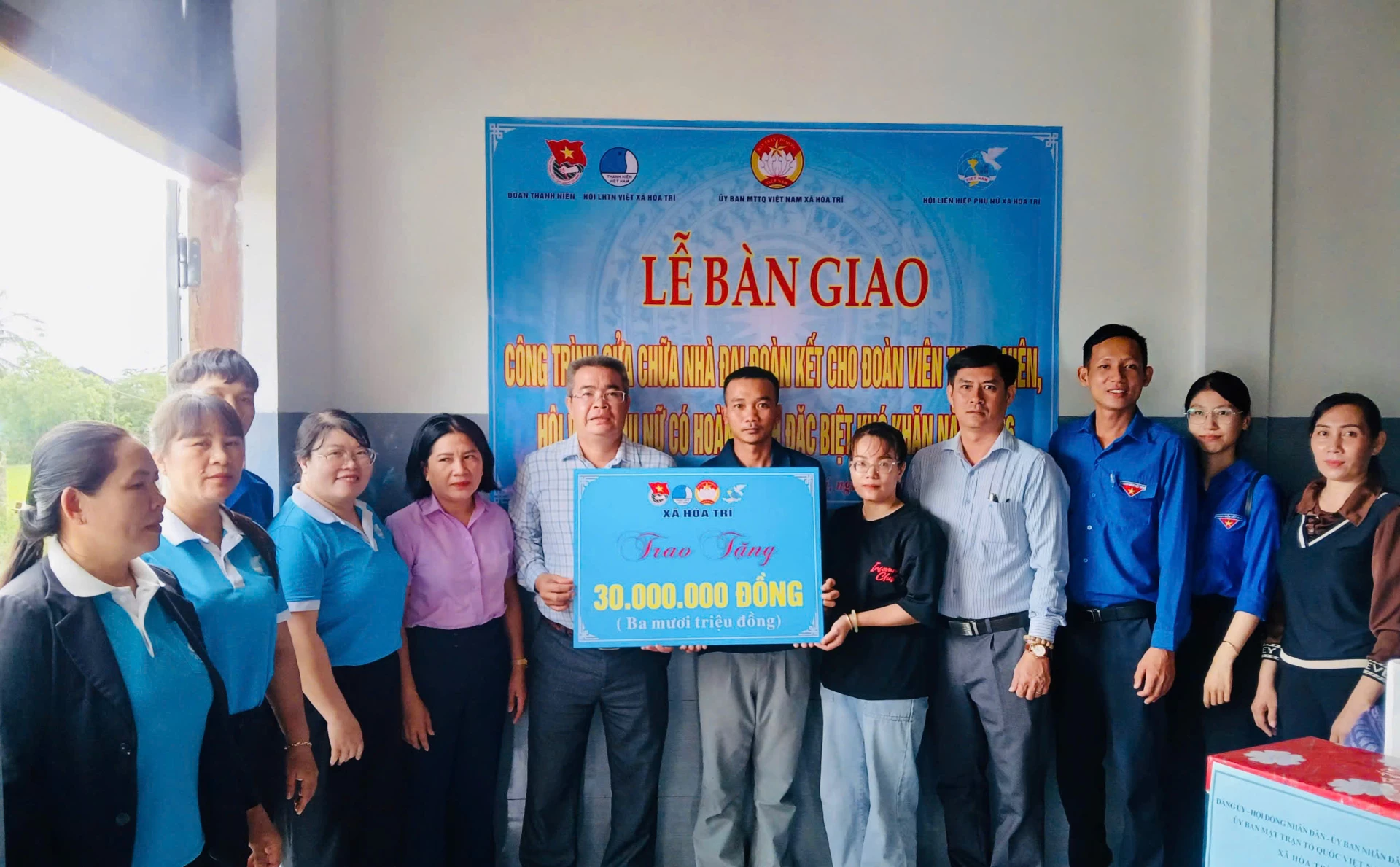 Đại diện các đơn vị trao bảng tượng trưng hỗ trợ kinh phí cho gia đình ông Nguyễn Thành Tấn.