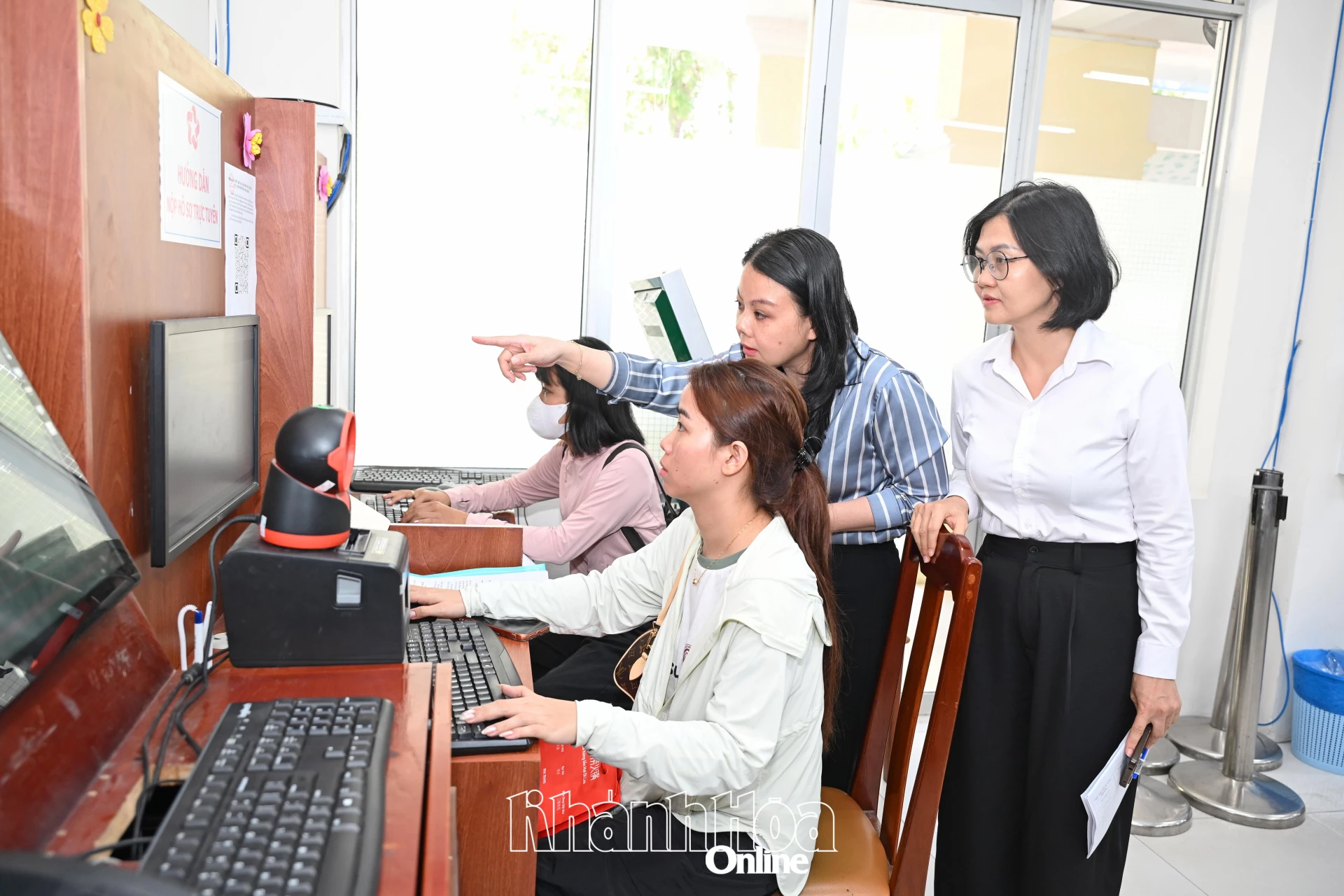 Thành viên đoàn kiểm tra công tác cải cách hành chính tỉnh (bìa phải) kiểm tra việc hướng dẫn người dân tại phường Nha Trang.