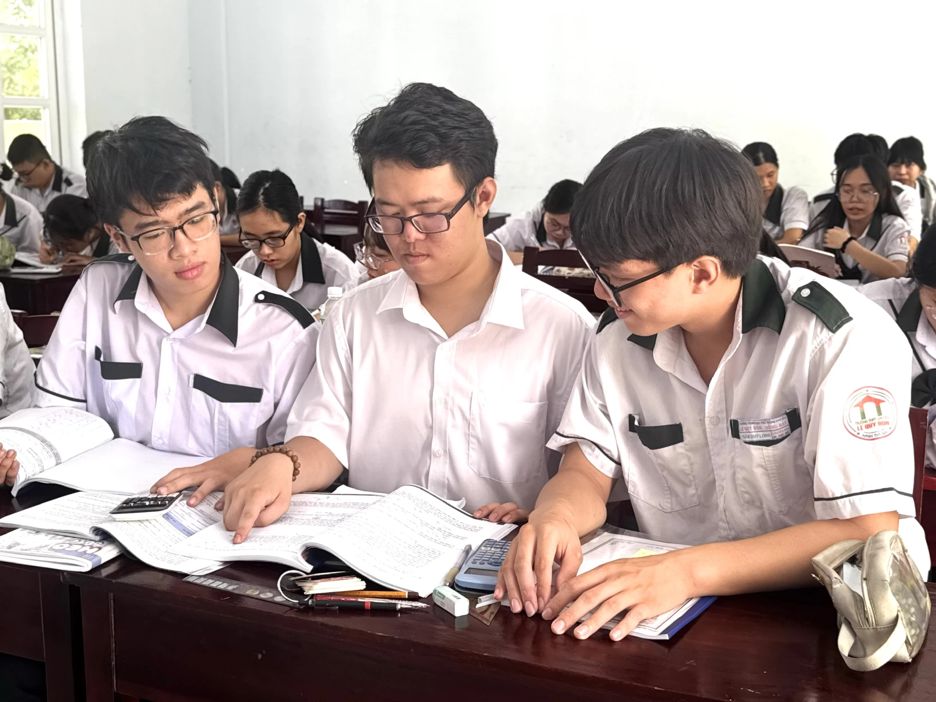 Gia Bảo (ngồi giữa) ôn tập bài cùng các bạn trong lớp.