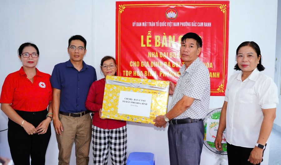 Tặng quà cho gia đình bà Bùi Thị Kim Hoa tại lễ bàn giao.