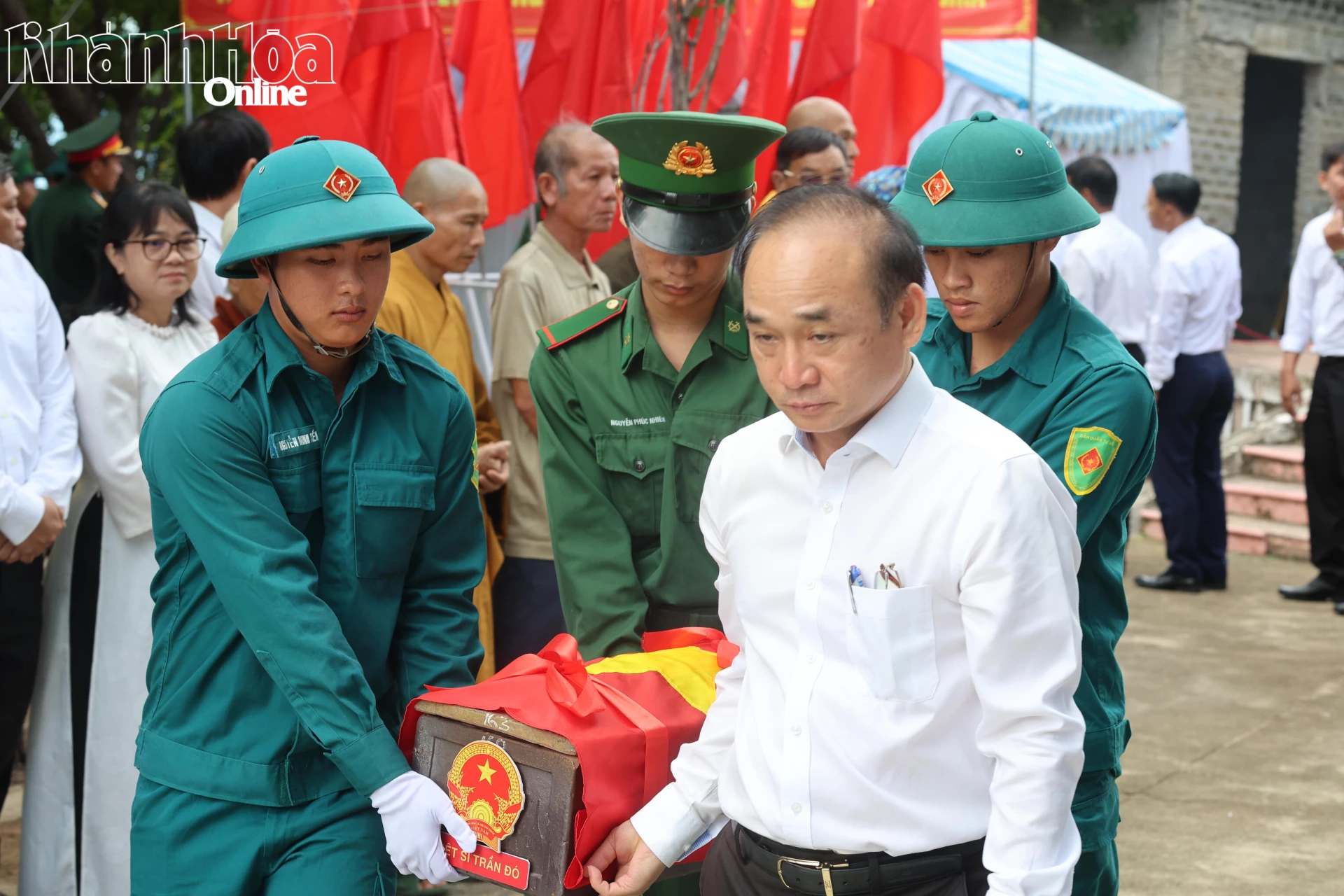 Các đại biểu và lực lượng chuyên trách di chuyển hài cốt lên phương tiện để di chuyển về Nghĩa trang liệt sĩ Ninh Thuận (Ảnh Minh Tuệ).