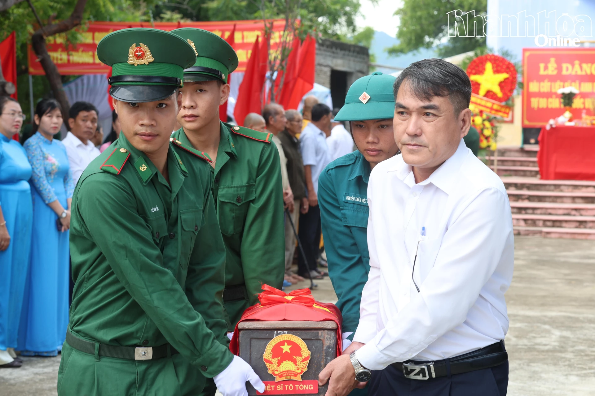 Các đại biểu và lực lượng chuyên trách di chuyển hài cốt liệt sĩ lên phương tiện để di chuyển về Nghĩa trang liệt sĩ Ninh Thuận (Ảnh Minh Tuệ).