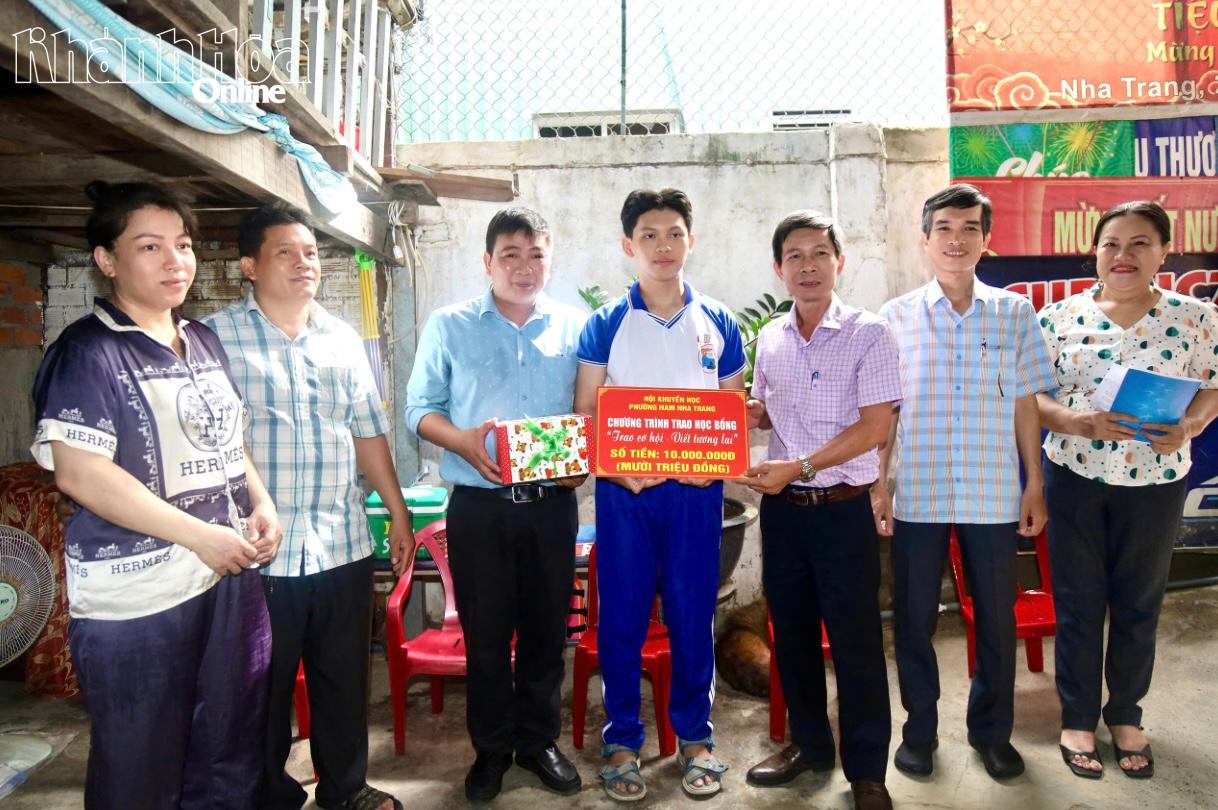 Ông Nguyễn Văn Minh (thứ 3 từ phải sang) trao học bổng cho em Nguyễn Tấn Tài.