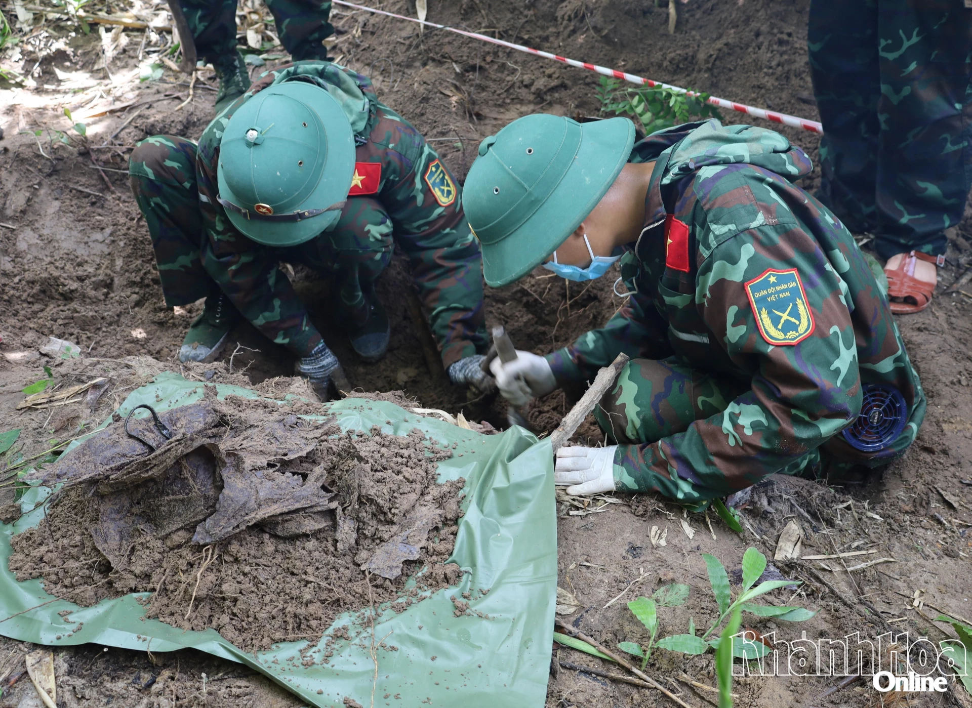 Cán bộ, chiến sĩ thận trọng xới từng lớp đất, lần tìm hài cốt liệt sĩ và di vật.