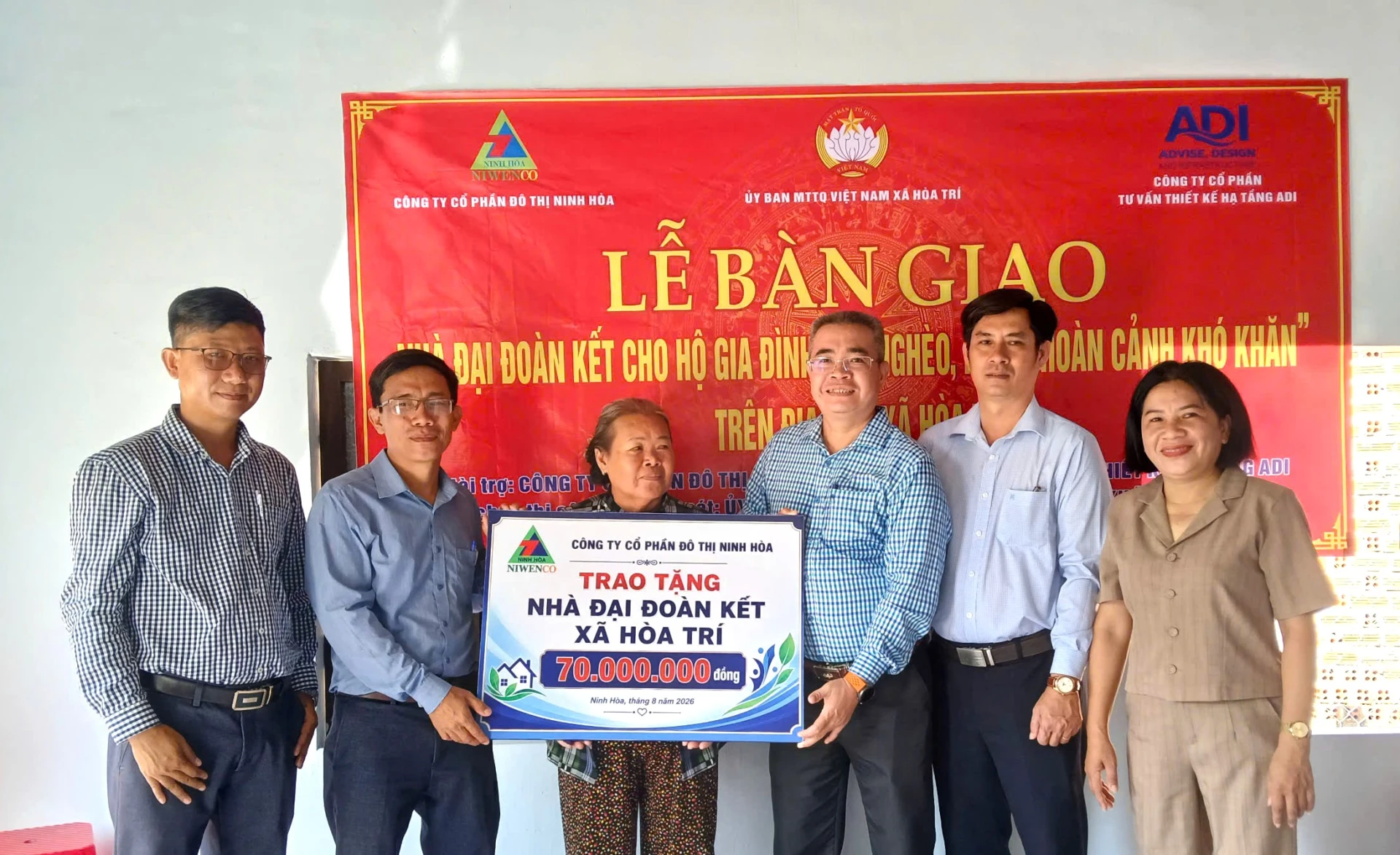 Lãnh đạo xã Hòa Trí và nhà tại trợ trao bảng tượng trưng căn nhà cho bà Nguyễn Thị Hiề.n
