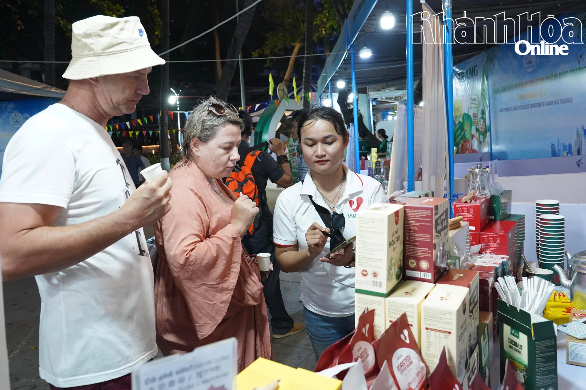 Khách hàng tìm hiểu thông tin sản phẩm thông qua các nền tảng số tại Triển lãm sản phẩm OCOP 2026 tại phường Nha Trang.