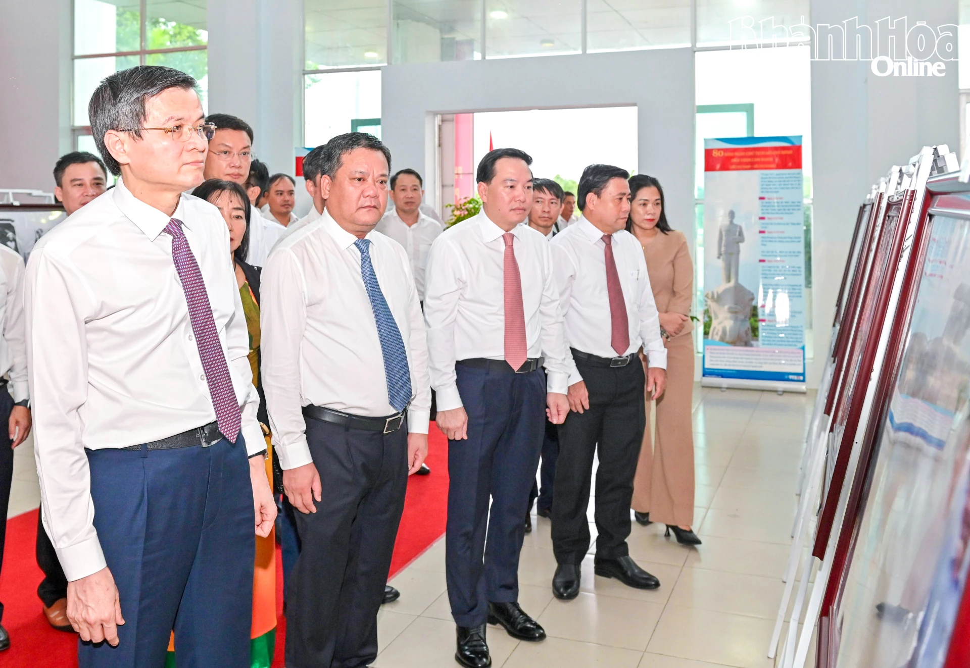 PGS.TS. Đoàn Minh Huấn và các đồng chí: Trần Phong, Hồ Xuân Trường, Lâm Đông cùng các đại biểu xem triển lãm ảnh, ảnh tư liệu về Chủ tịch Hồ Chí Minh.