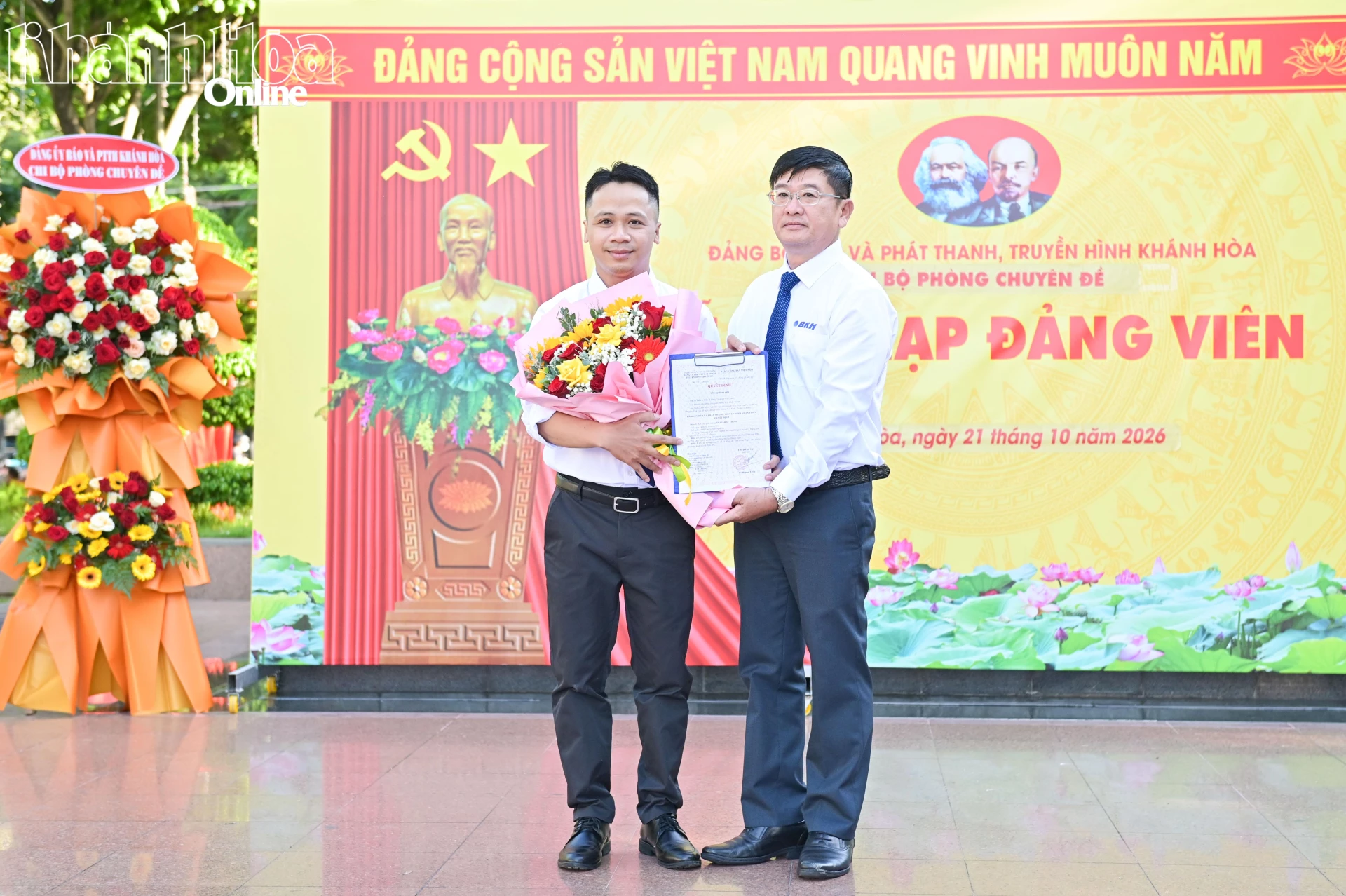 Ông Lê Hoàng Triều - Bí thư Đảng ủy, Giám đốc Báo và Phát thanh, Truyền hình Khánh Hòa trao quyết định, tặng hoa chúc mừng đảng viên mới Thái Khắc Thịnh.