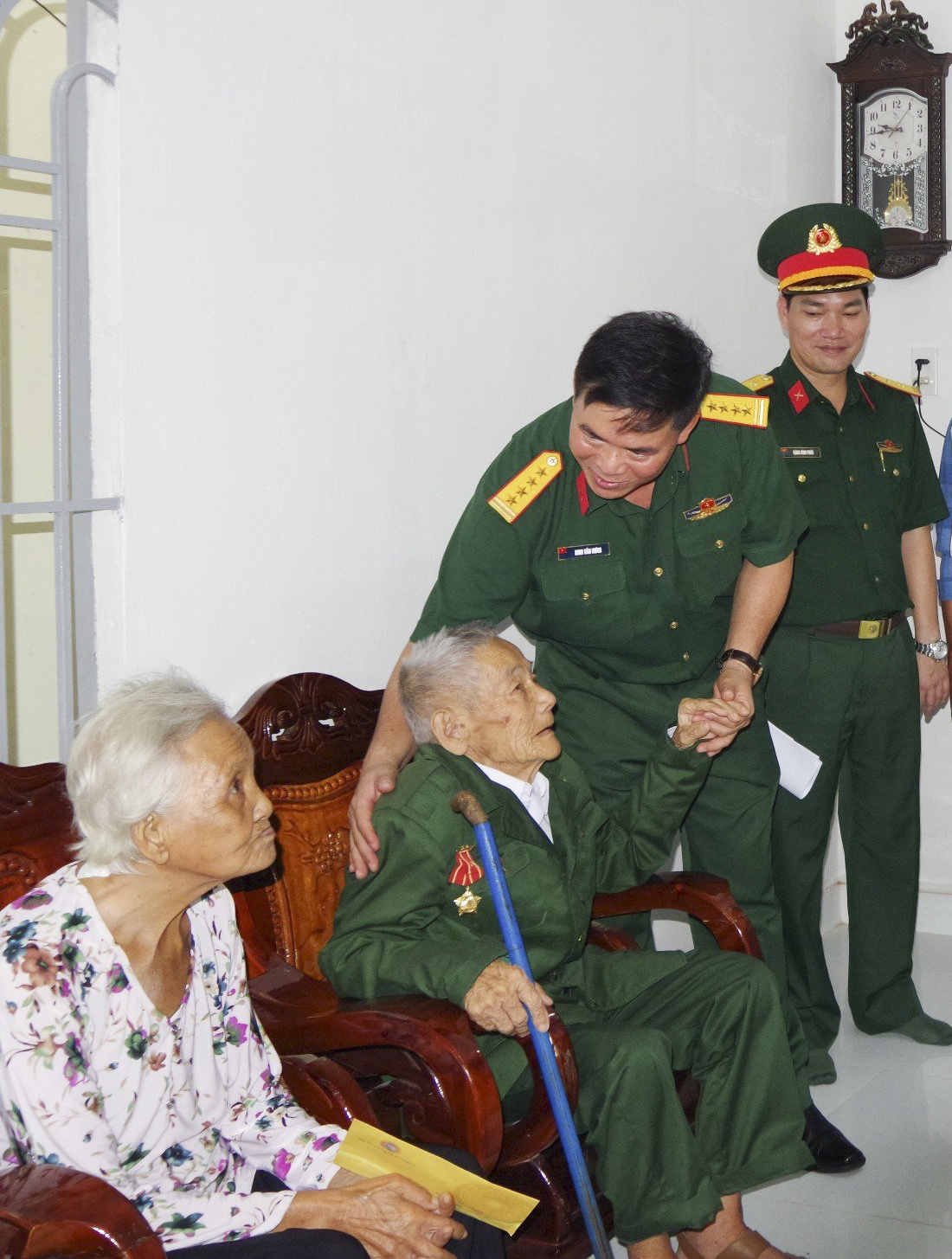 Đại tá Đinh Văn Hưng chia sẻ niềm vui cùng ông Lê Văn Quyền trong căn nhà mới.
