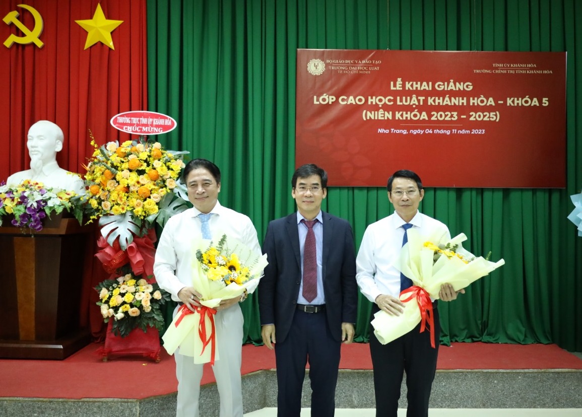 Tiến sĩ Lê Trường Sơn - Hiệu trưởng Trường Đại học Luật TP. Hồ Chí Minh tặng hoa cho đồng chí Nguyễn Khắc Toàn và đồng chí Đinh Văn Thiệu. 