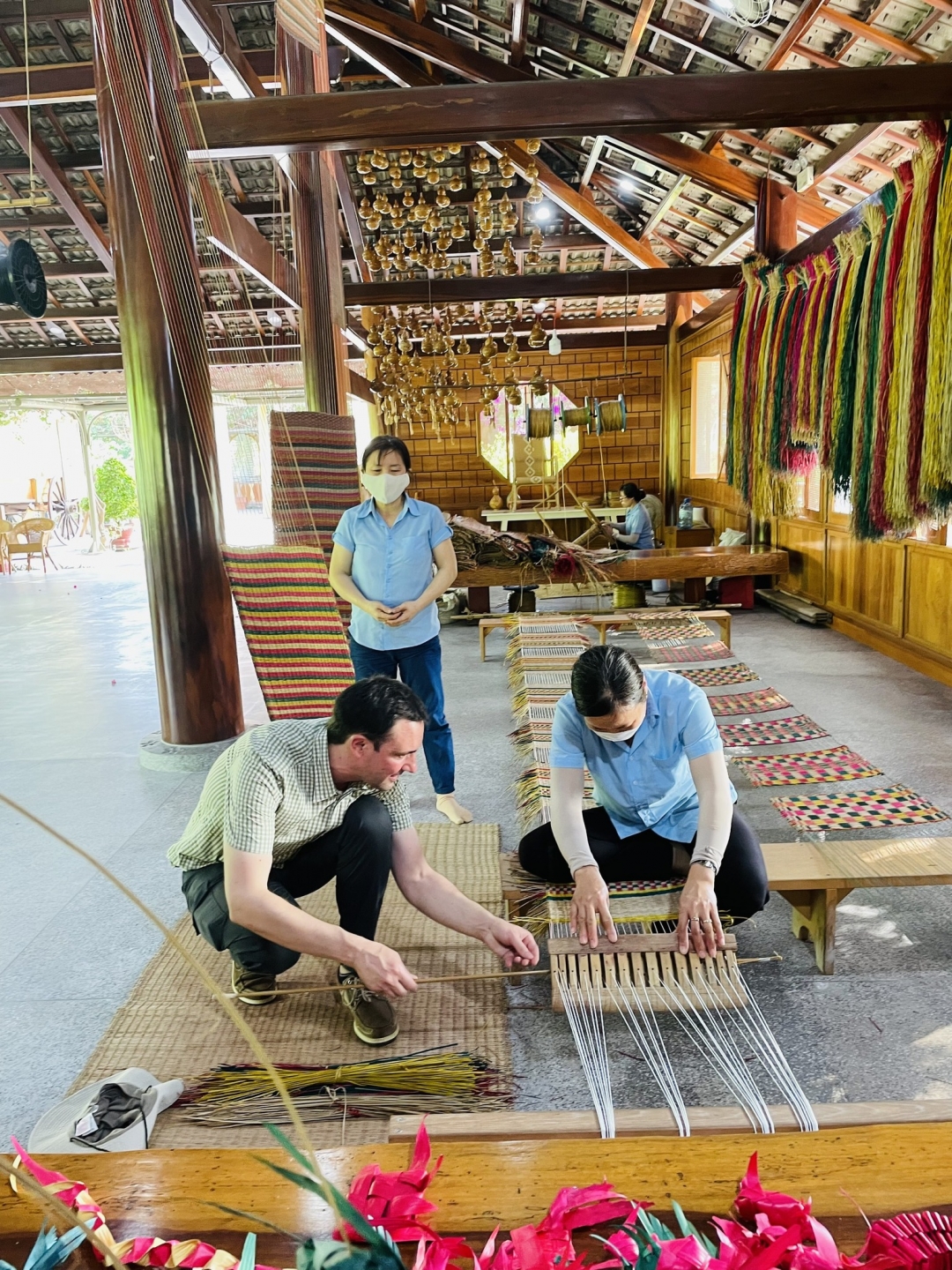 International visitors learn about traditional sedge mat weaving techniques.
