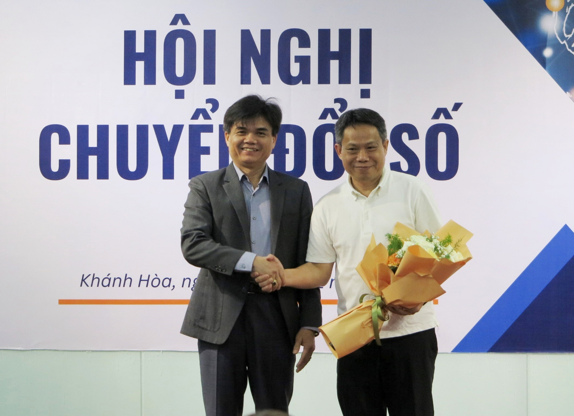 Tiến sĩ Phan Phiến - Hiệu trưởng Trường Đại học Khánh Hòa (bên trái) tặng hoa cho Tiến sĩ Trương Bá Hà – Giám đốc Công ty PSC.