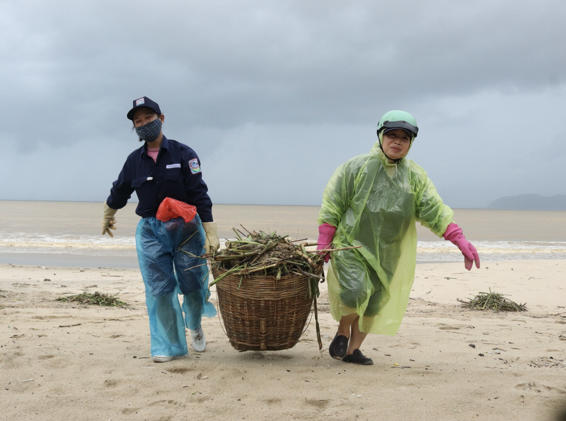 Hai nữ công nhân vận chuyển rác trôi dạt vào bãi biển Nha Trang.