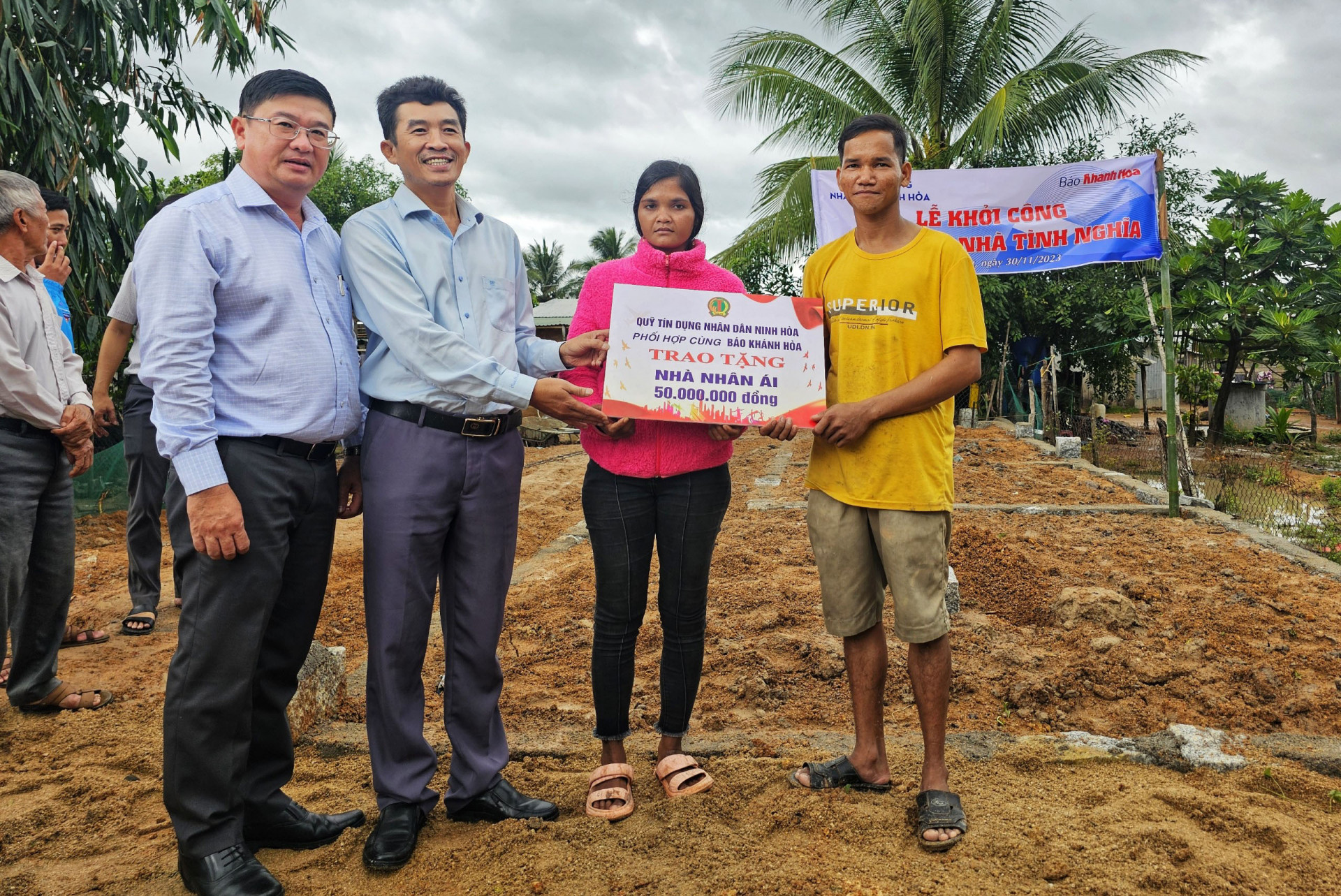 Ông Lê Hoàng Triều - Phó Tổng Biên tập Báo Khánh Hòa và ông Nguyễn Tấn Lực - Chủ tịch Hội đồng Quản trị Quỹ Tín dụng nhân dân Ninh Hòa trao biểu trưng 50 triệu đồng cho gia đình ông Cao Tâm.