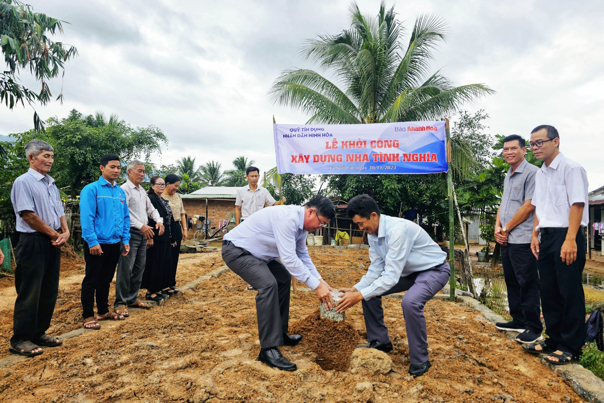 Ông Lê Hoàng Triều - Phó Tổng Biên tập Báo Khánh Hòa và ông Nguyễn Tấn Lực - Chủ tịch Hội đồng Quản trị Quỹ Tín dụng nhân dân Ninh Hòa đặt viên đá khởi công nhà tình nghĩa cho hộ ông Cao Tâm.