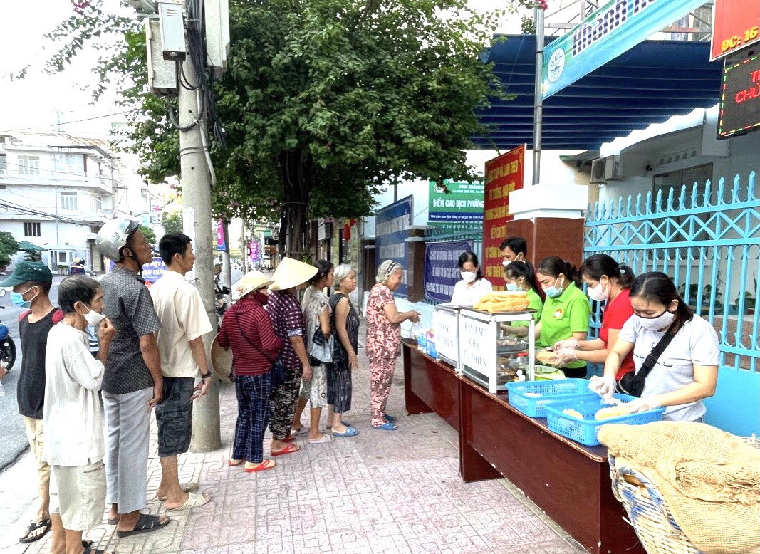 Người dân xếp hàng nhận bánh mì và nước uống do Mặt trận phường Vạn Thắng, TP. Nha Trang trao tặng
