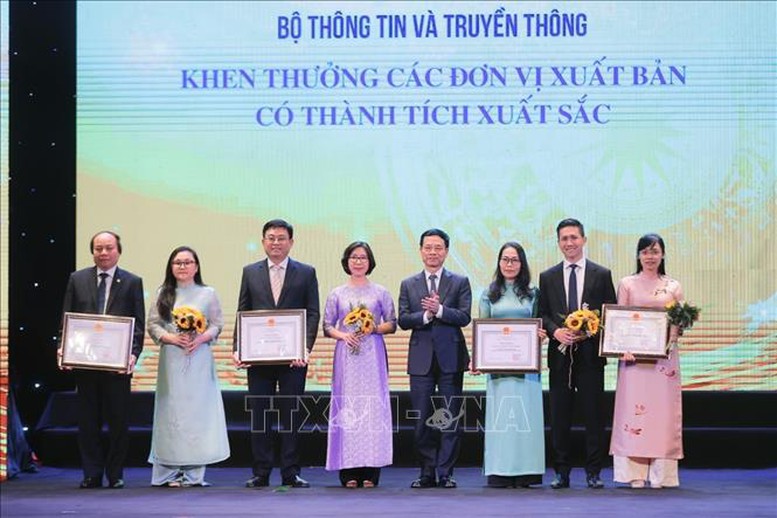 Bộ trưởng Bộ Thông tin và Truyền thông Nguyễn Mạnh Hùng trao tặng Bằng khen của Bộ trưởng cho các đơn vị xuất bản có thành tích xuất sắc - Ảnh: TTXVN

