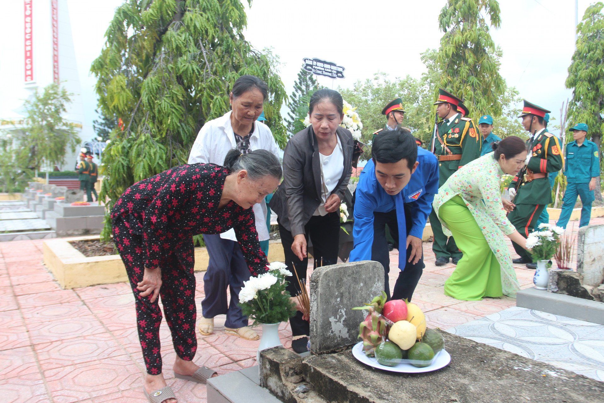 Bà Mạnh cùng các con, cháu bên phần mộ liệt sĩ Trần Thơm.